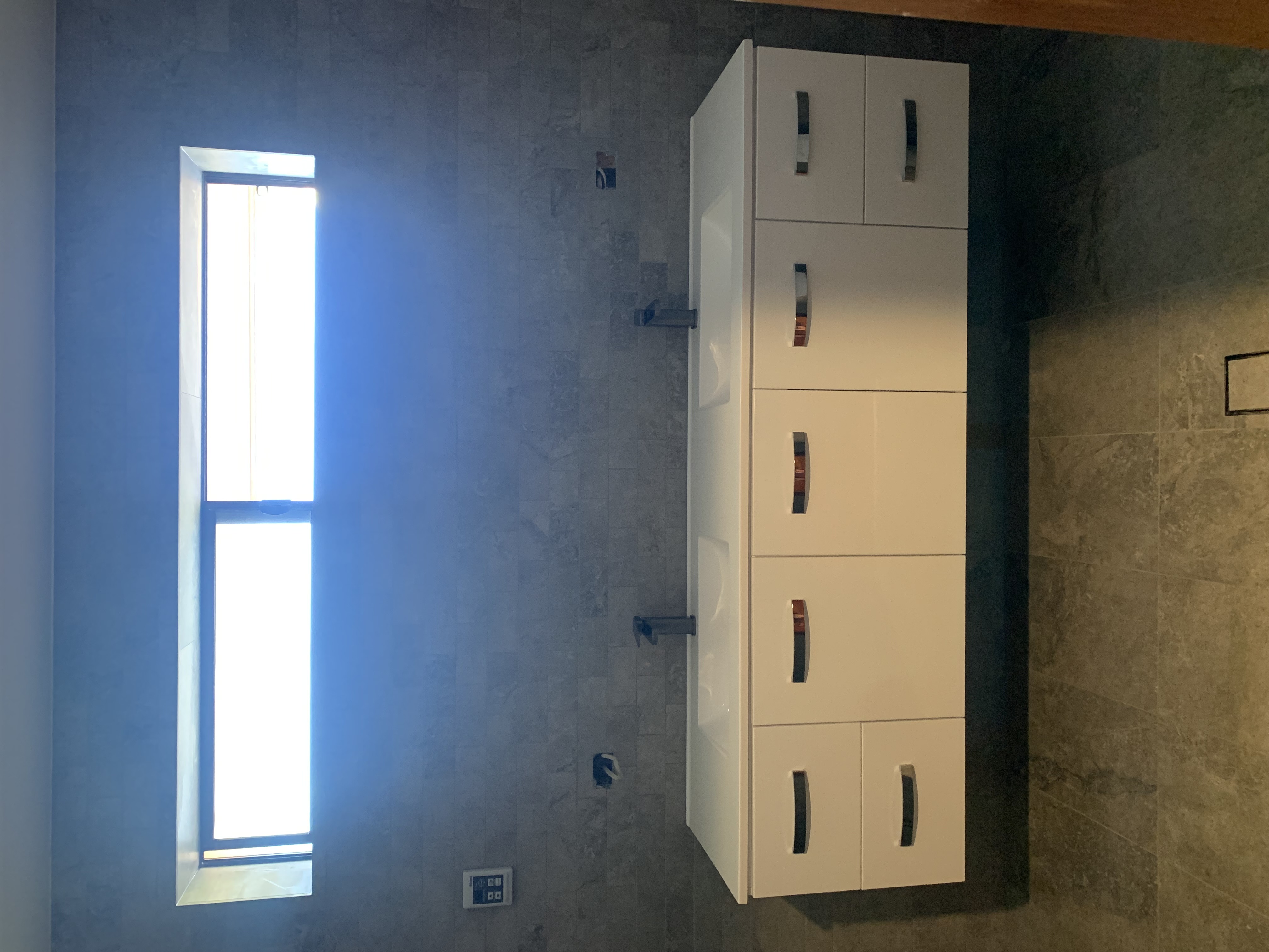Modern bathroom renovation with floating double vanity and tiled walls